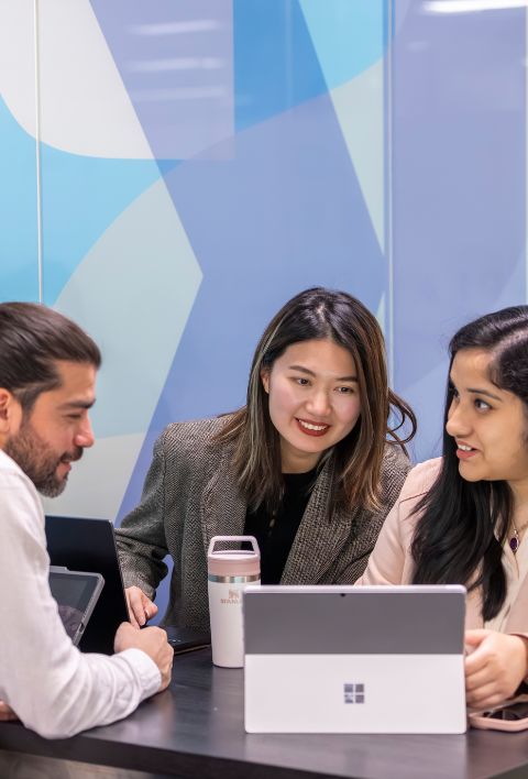 three-students-talking-in-front-of-a-laptop